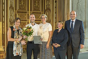 five persons at award ceremony